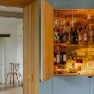 Drinks cabinet integrated into blue timber wall