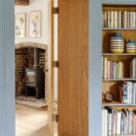 Library leading through to living room with fireplace