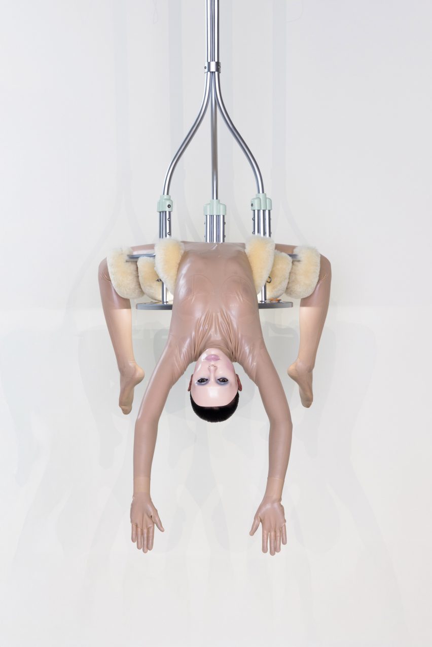 Woman hanging from a chandelier designed by Bianca Censori