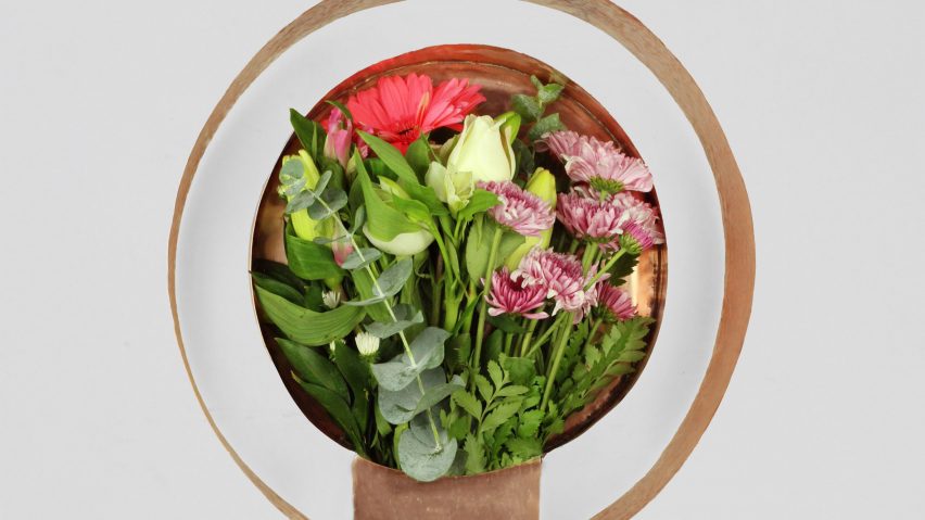 a copper vase with flowers in