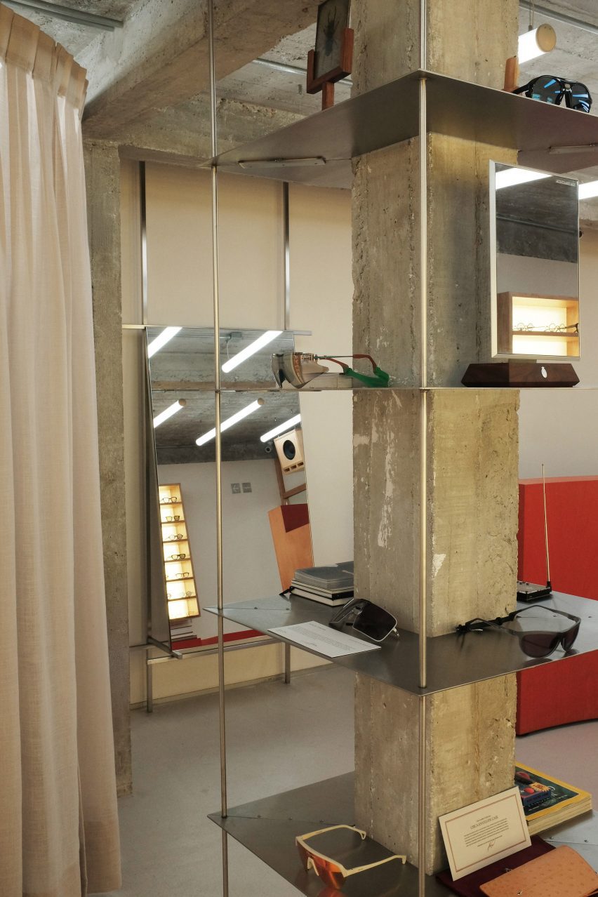 Thin metal shelves suspended on thin rods around a concrete column