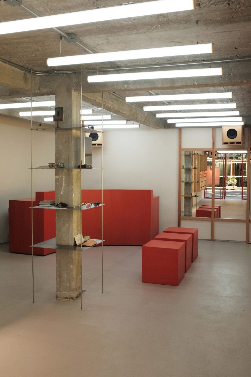 Bright red stools and a curved service counter pop against a muted interior