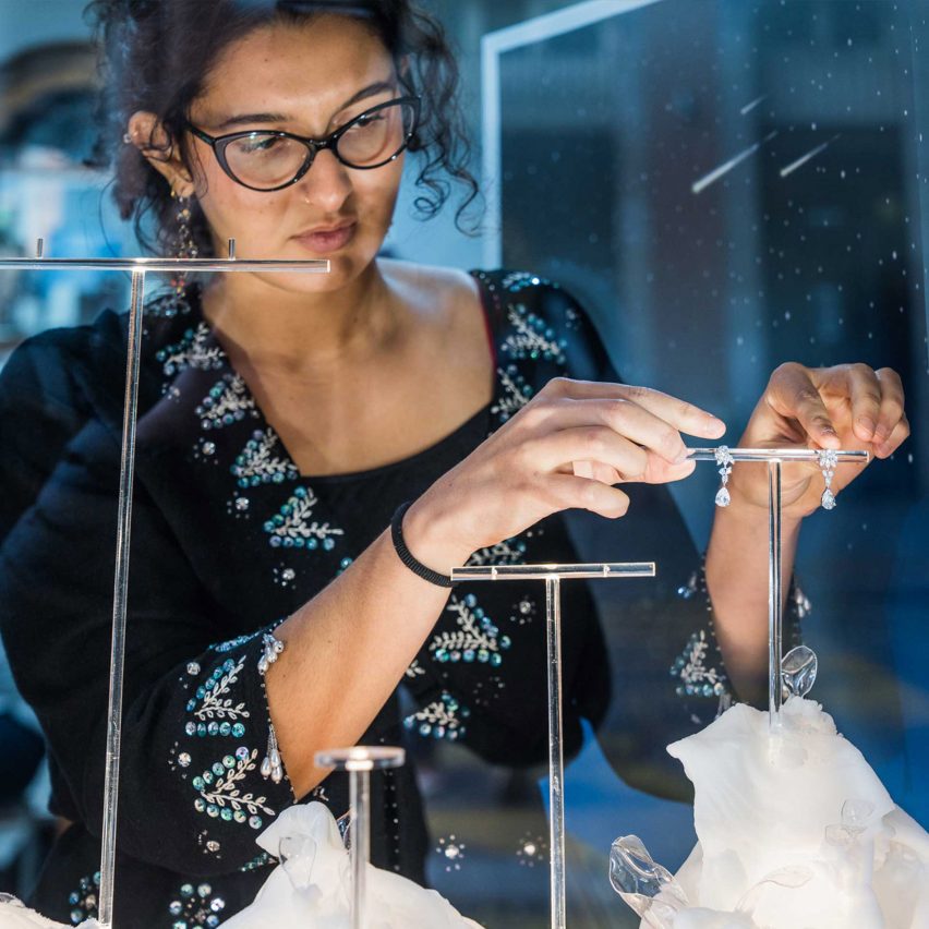 person touching jewellery display
