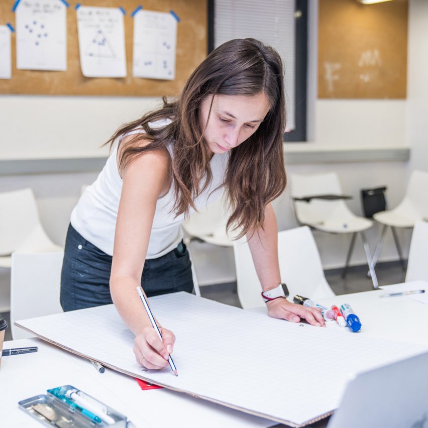 a person drawing at a desk