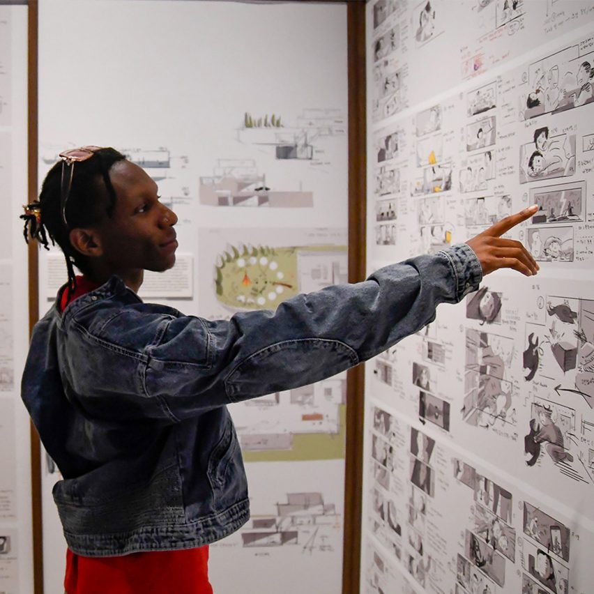 person pointing at drawings on the wall