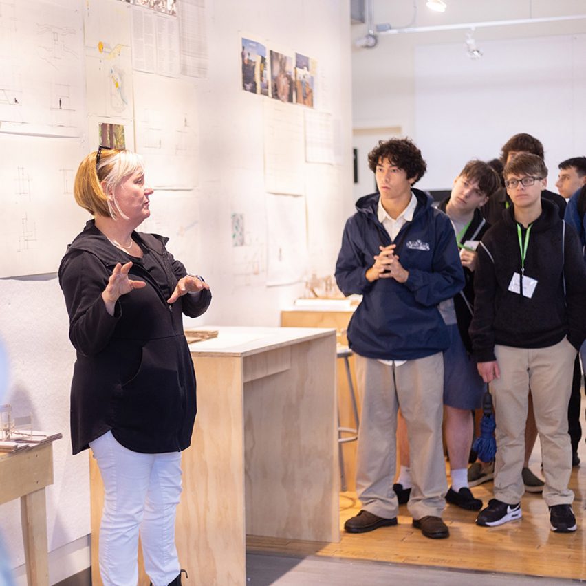people gathered in a room with architectural drawings and models
