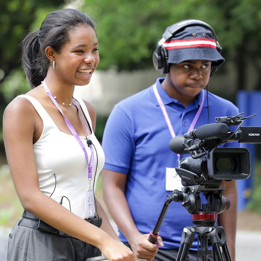 two people standing behind a camera