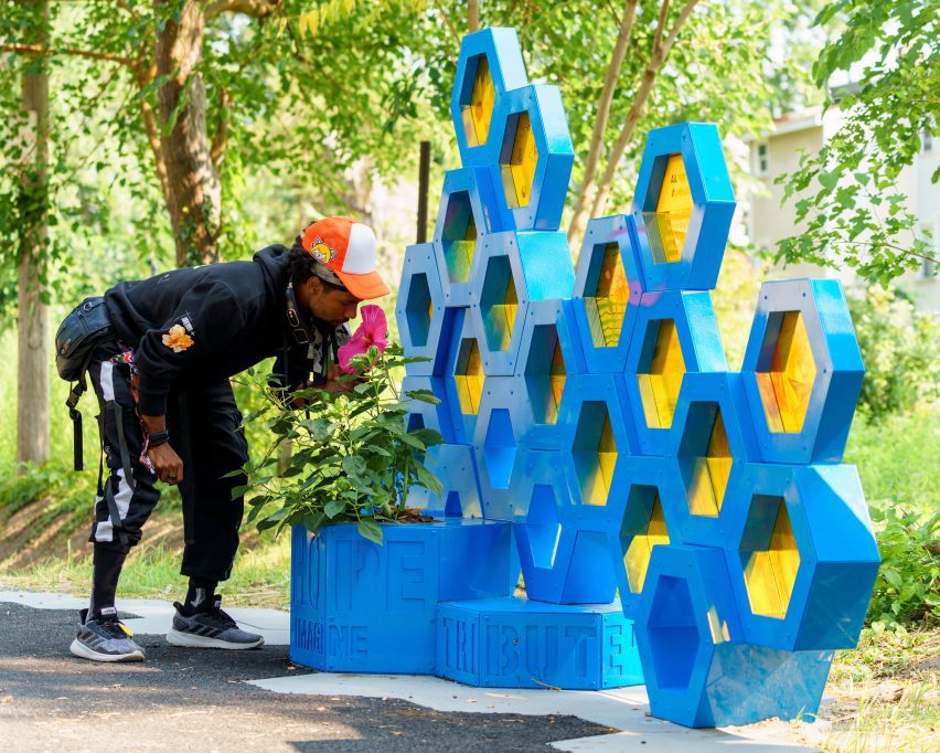 man putting plant into blue and yellow planter
