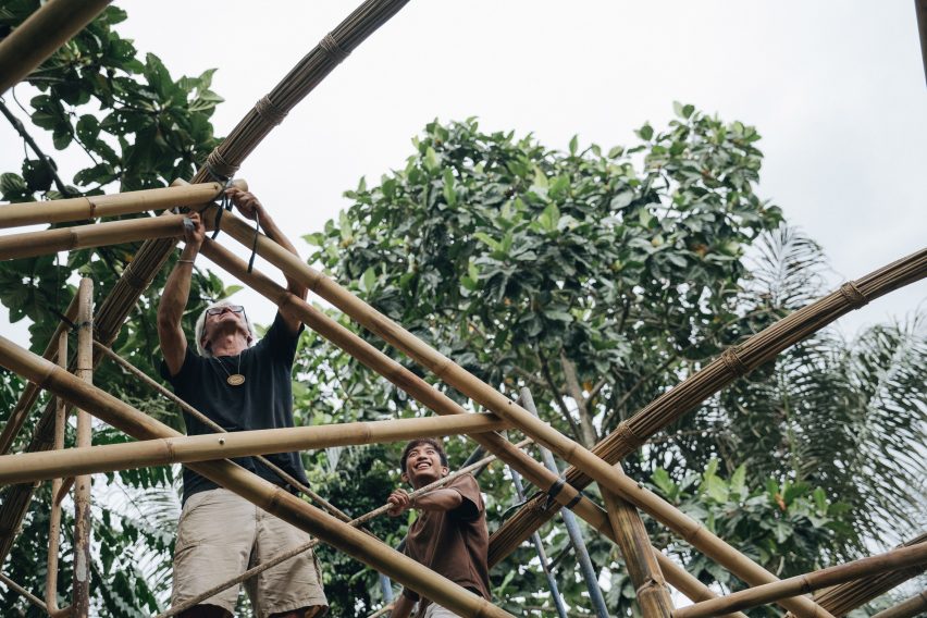 People building a house from bamboo