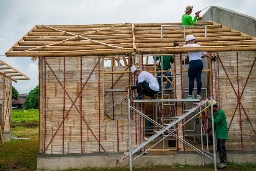 People building a house from bamboo