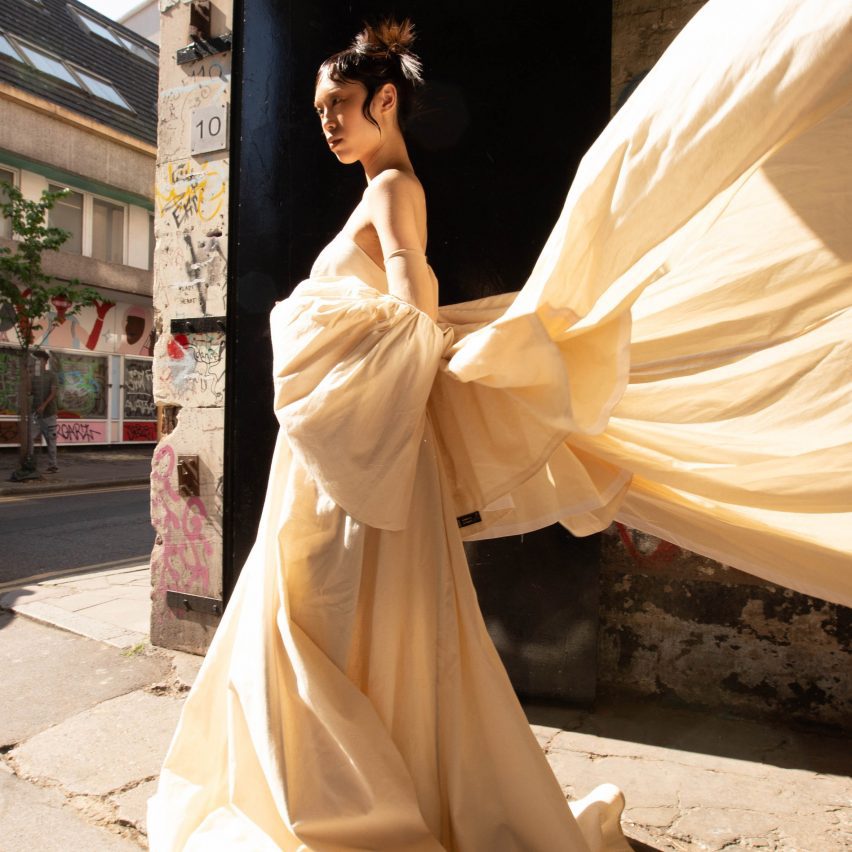 a photograph of a model wearing a white dress