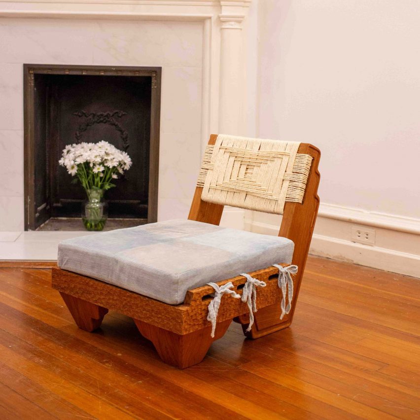 a brown wooden chair with a blue cushion on it