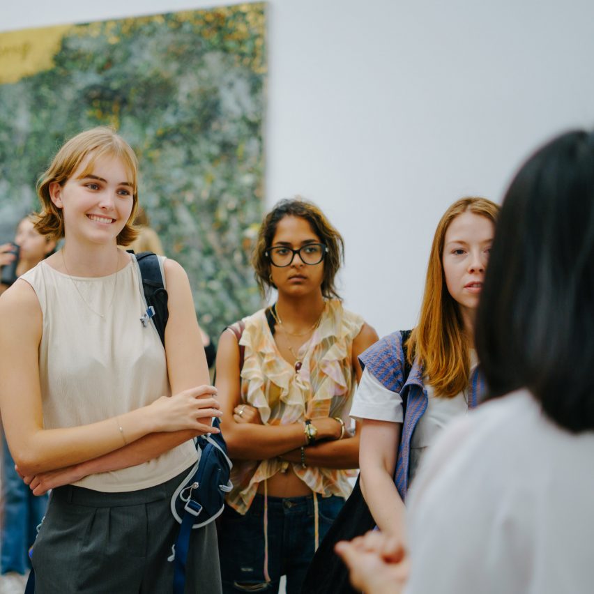 people standing in front of artwork in a gallery