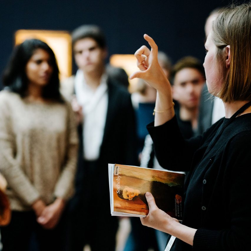 person talking to a group in a gallery