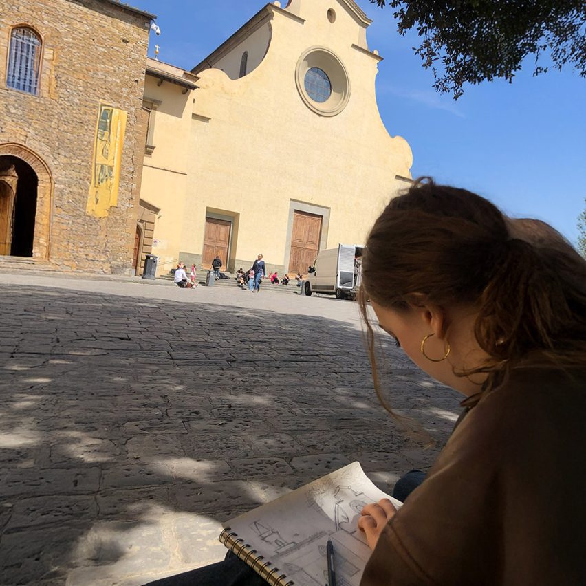 a photograph of a person drawing a building
