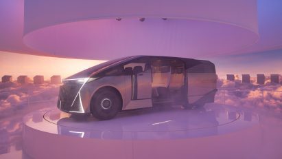 Person stands in a mist-filled circular space facing a six-wheeled Lexus Concept vehicle