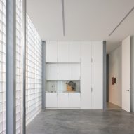 Garage with glass brick outer wall and cement floor