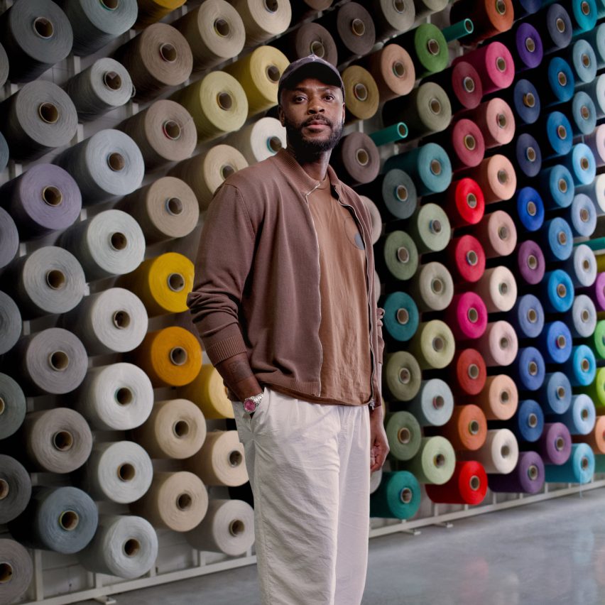 Yinka Ilori in front of colourful thread
