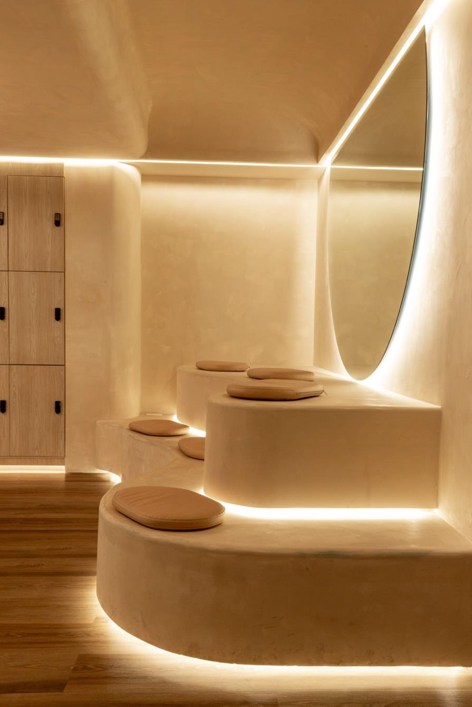 Warm-toned plaster covers the walls, ceiling and tiered seting, while lines of light highlight their junctions