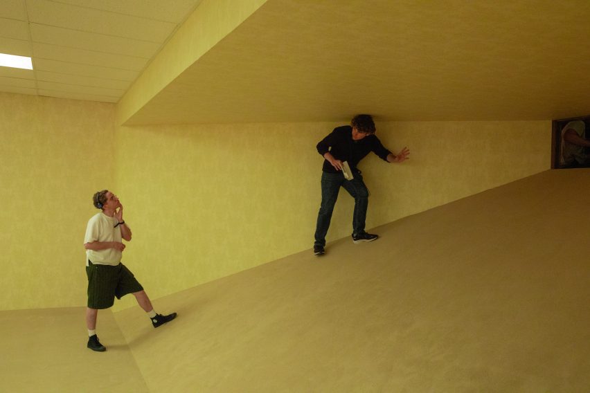 Behind-the-scenes photo from Backrooms showing director Kane Parsons climbing up a raked floor into a shrinking space
