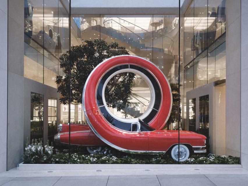 A looping red Cadillac in a Dior window display by Alex Chinneck