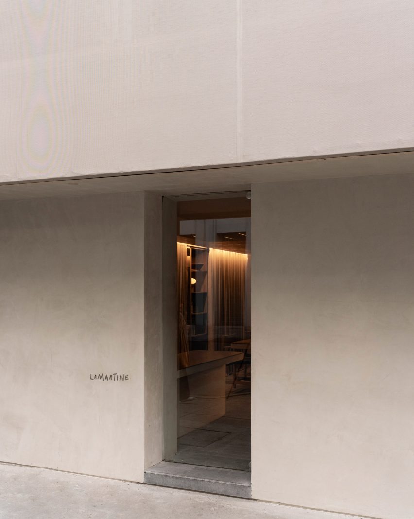Hotel entrance via a glass door set into a textured plaster wall