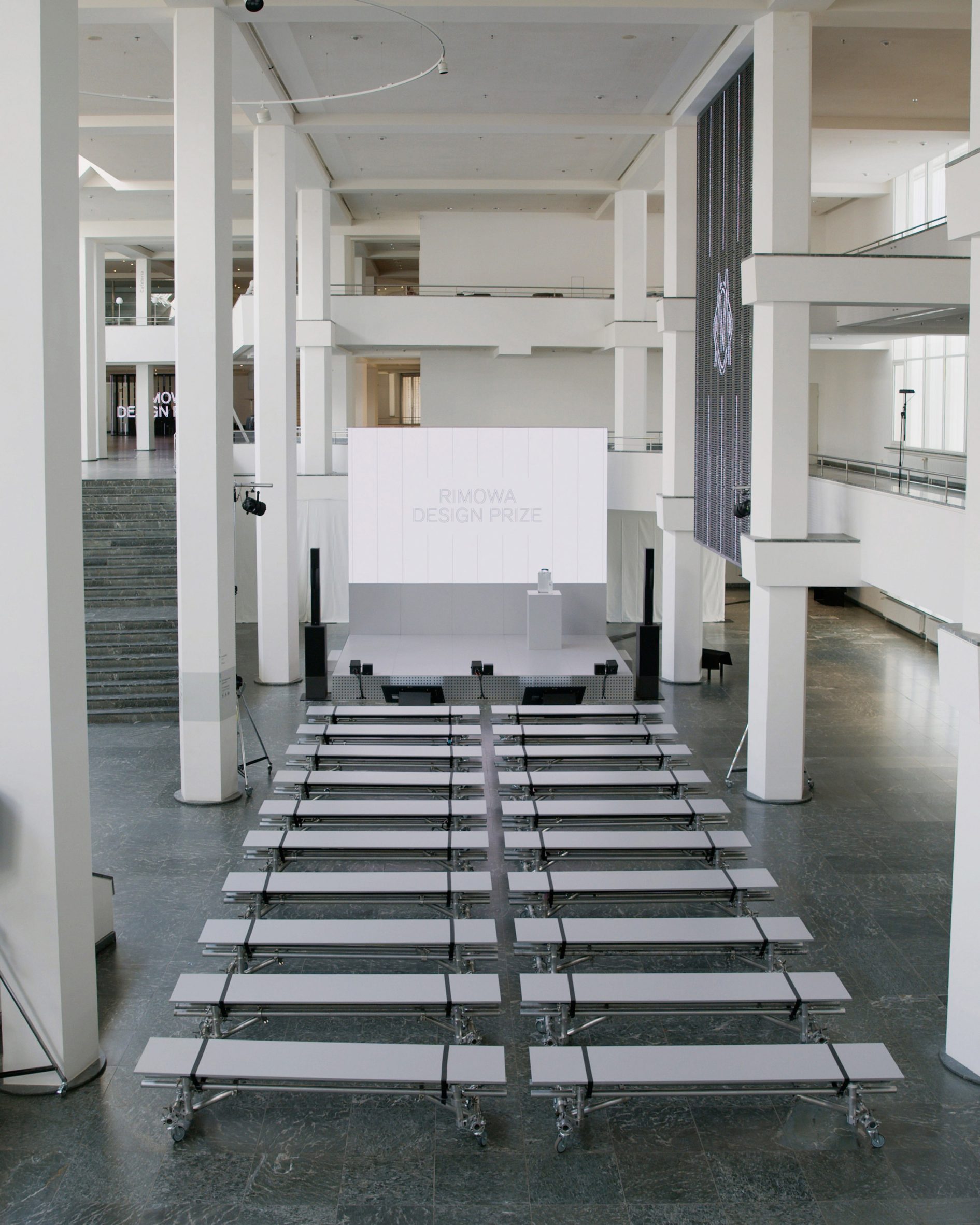 Una vista amplia de la sede de los Rimowa Design Awards, con filas de asientos frente al escenario