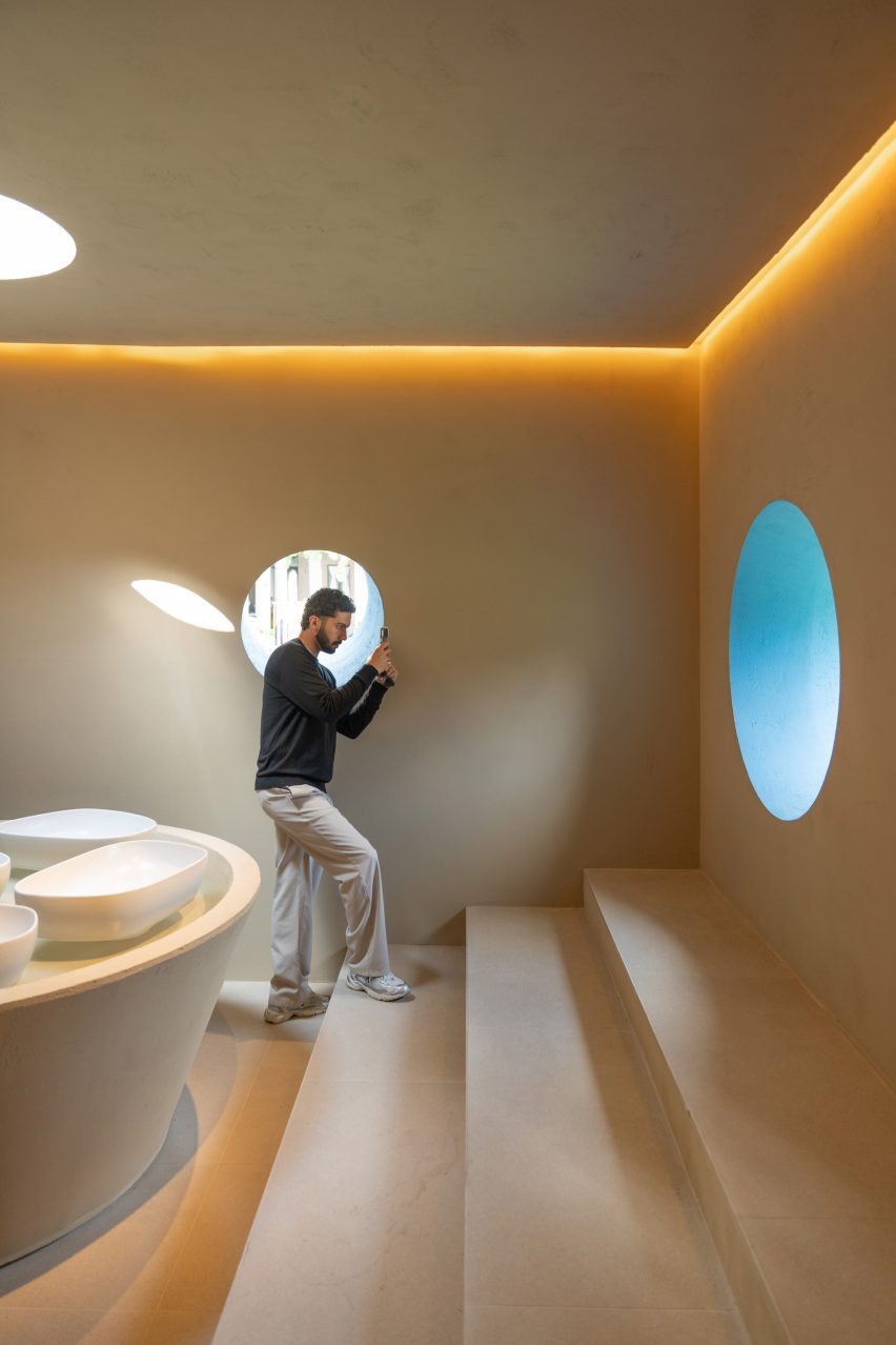 Person taking a photo through round blue window