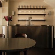 Curving communal table forms "archipelago of steel" at centre of Kiez Kebab restaurant