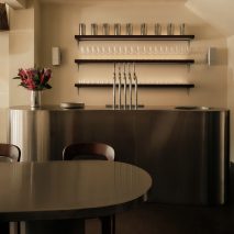 Curving communal table forms "archipelago of steel" at Kiez Kebab