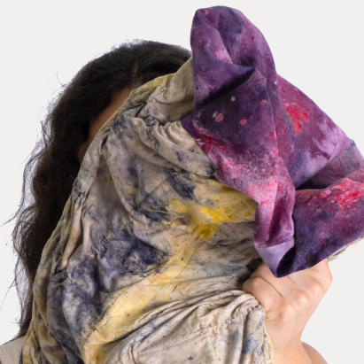 Person holding textile project up to face