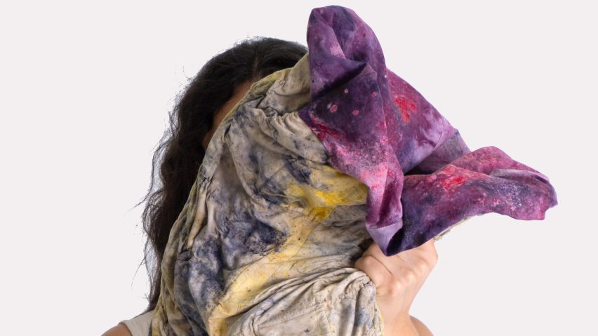 Person holding textile project up to face