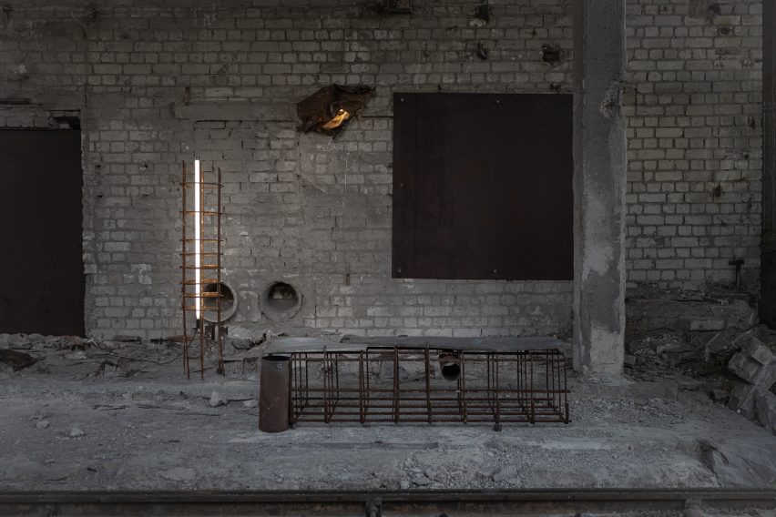 Image of a derelict basement-type space with concrete and a rusted metal bench.
