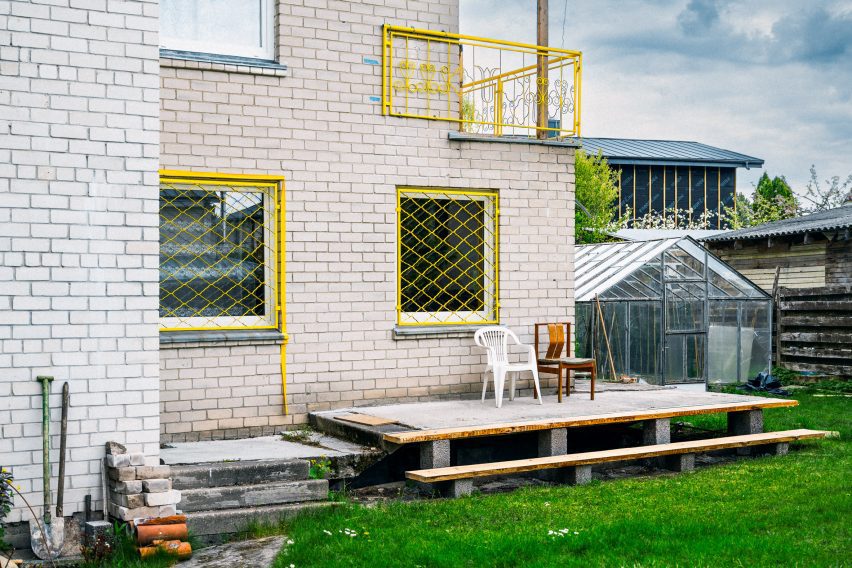 Image of a garden setting with decking, two chairs and windows covered in bright yellow caging.