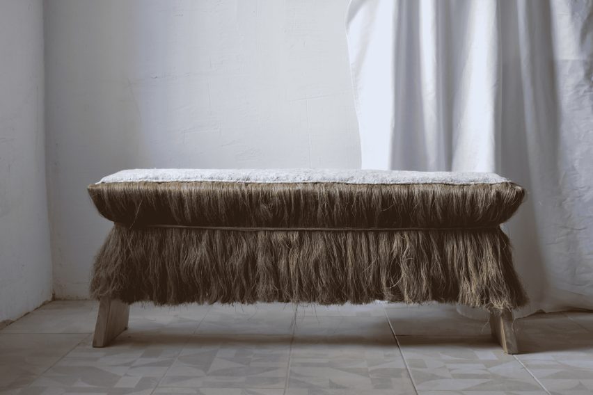 Photograph of a bench with hair-like tassels.