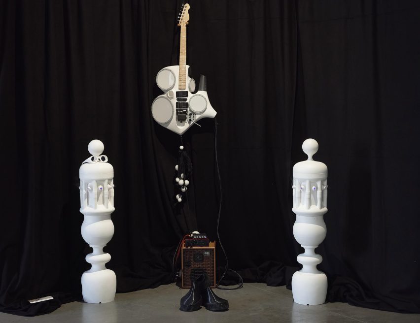 Photograph of an installation with music-related objects, including an amp and a stylised guitar.