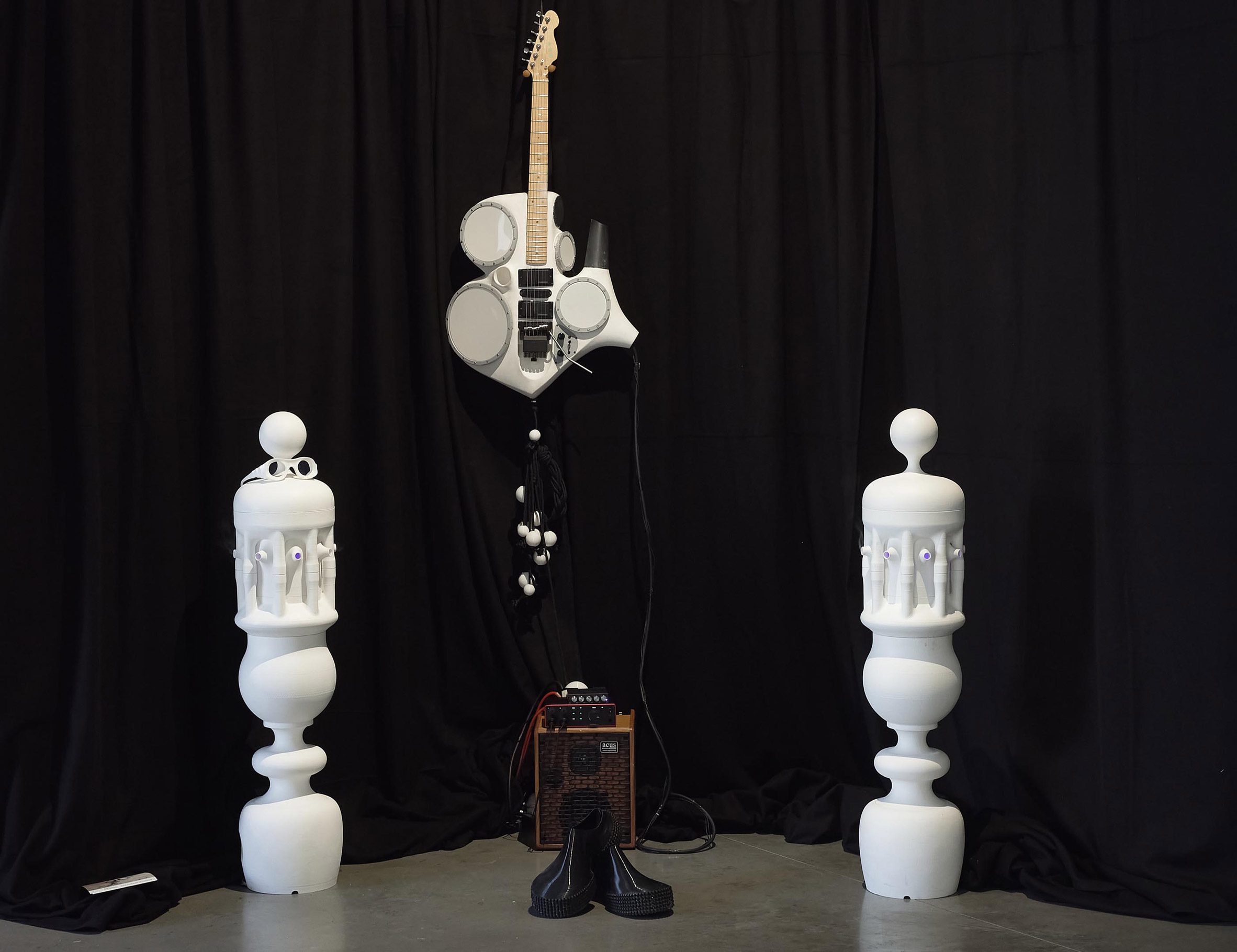 Photograph of an installation with music-related objects, including an amp and a stylised guitar.