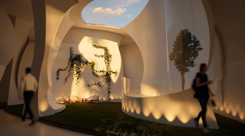 Photo of a public space with curved walls, sky light and chairs