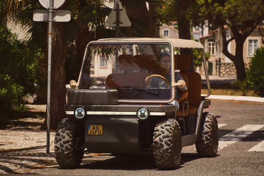 Photo of the Amble One buggy in street legal mode with a box instead of a basket on the front, driving down a street
