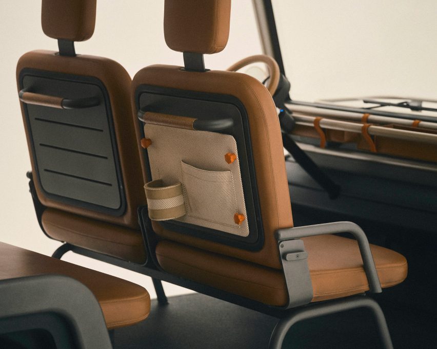 Studio photo of the back of the front passenger seats of the Amble One, showing a canvas pocket and cupholder accessory attached to the back of a seat