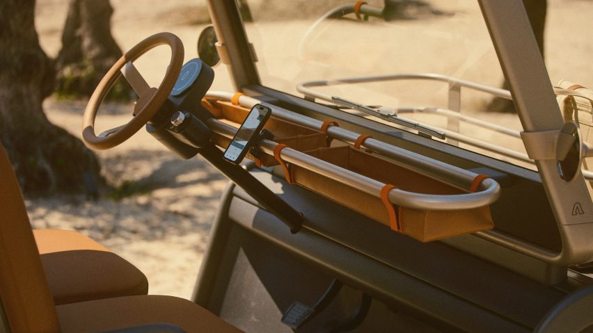Photo of the interior of the Amble One buggy showing a minimal instrument panel instead of a conventional dashboard, with a mobile phone docked in an attachment on a tubular metal frame