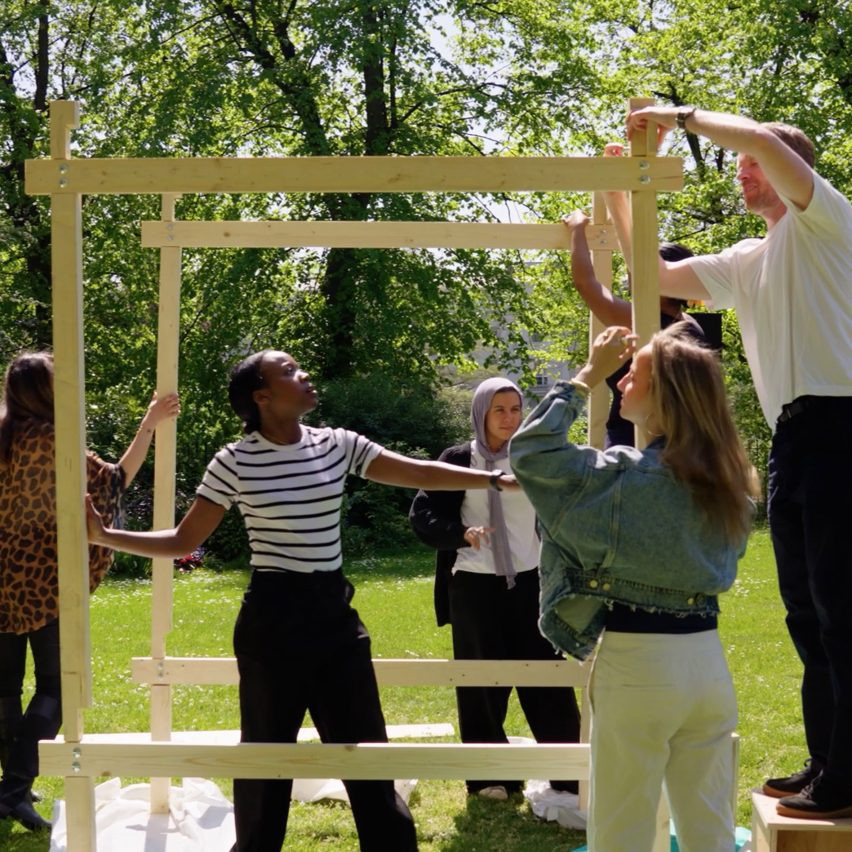 Students constructing a wooden structure outside
