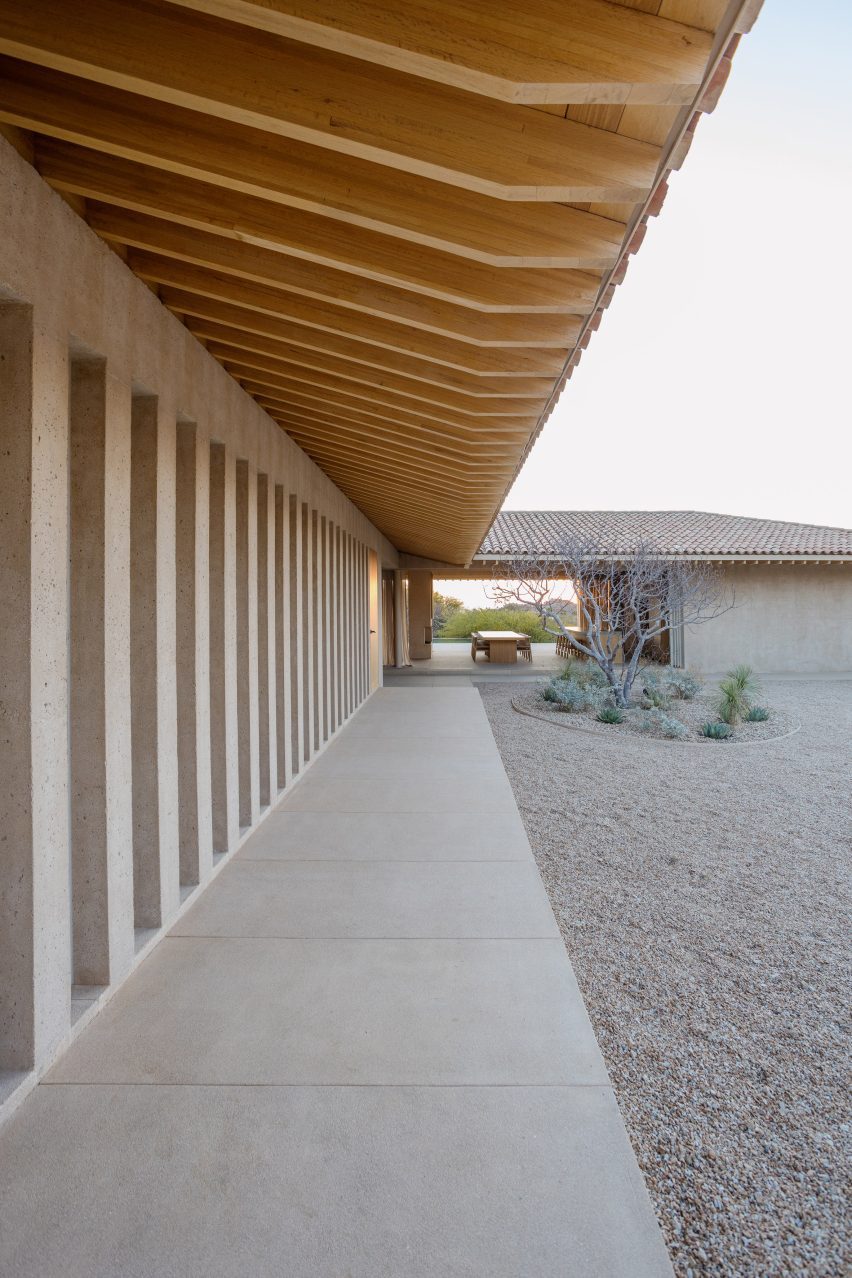 A home topped with L-shaped roofs with deep overhangs