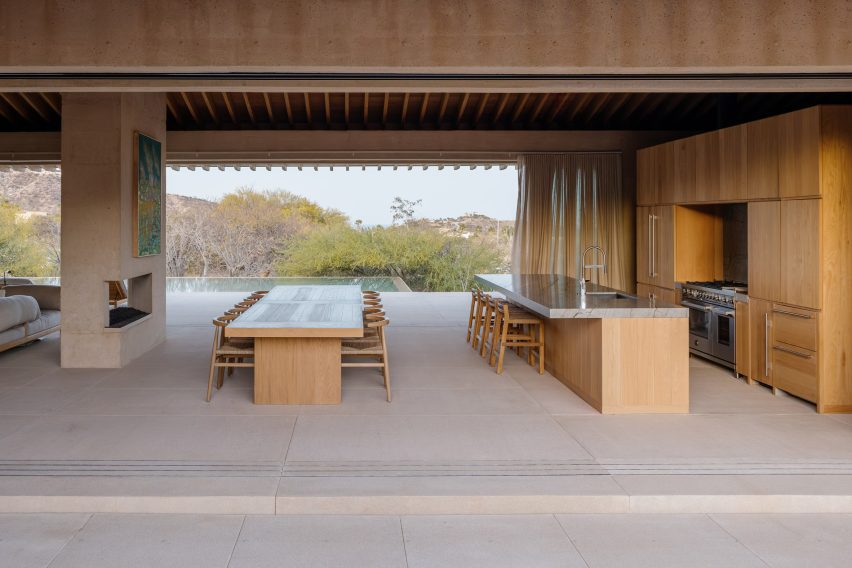 Living volume with fully retracted walls that connect a courtyard with a pool terrace