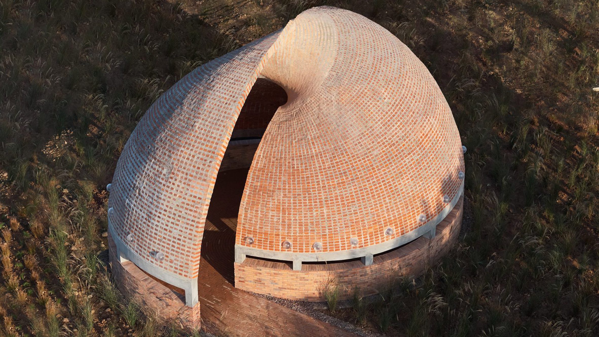https://static.dezeen.com/uploads/2026/06/curvy-brick-buildings-roundup_dezeen_2364_hero_1.jpg
