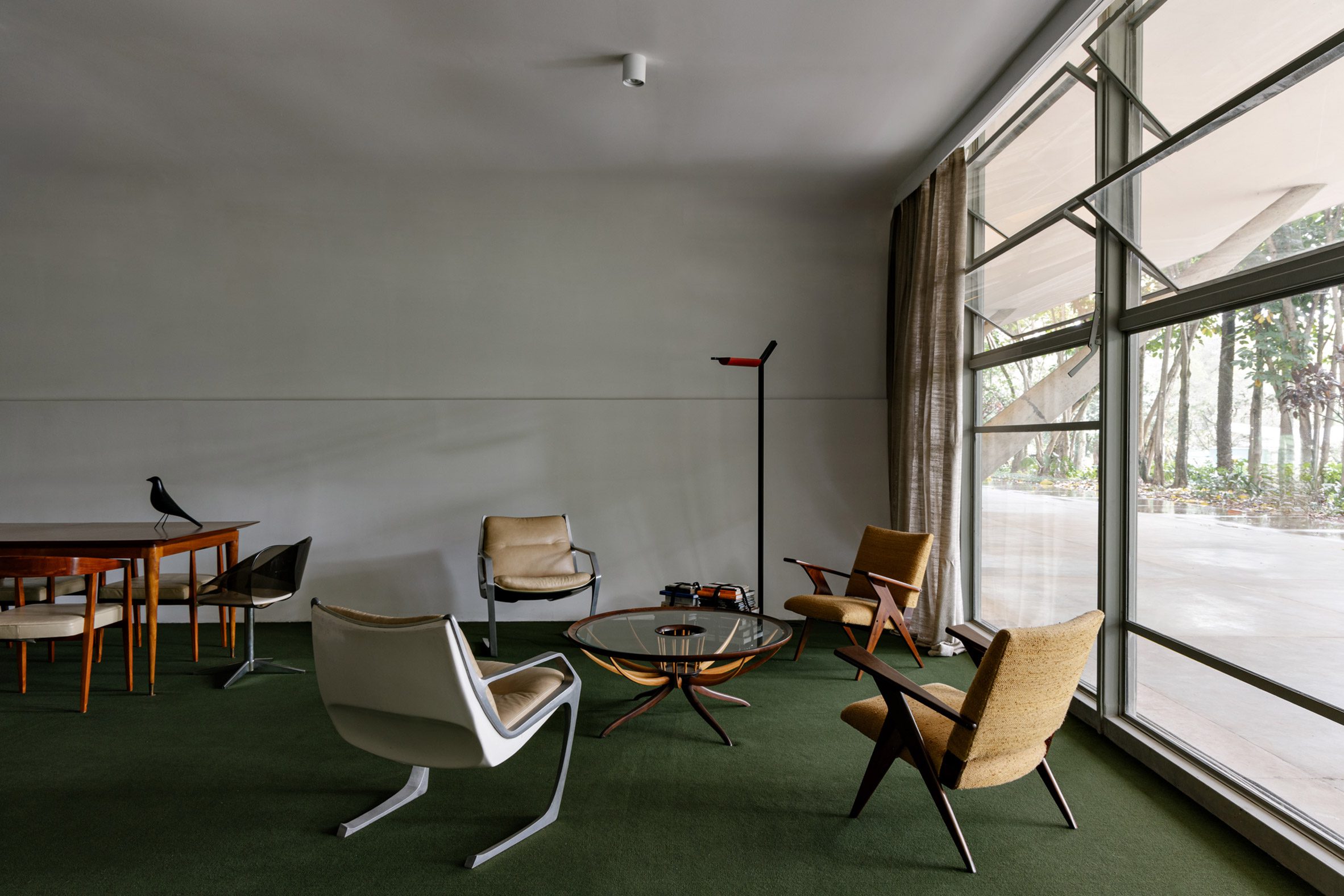 A display of modernist Brazilian furniture in a green-carpeted room