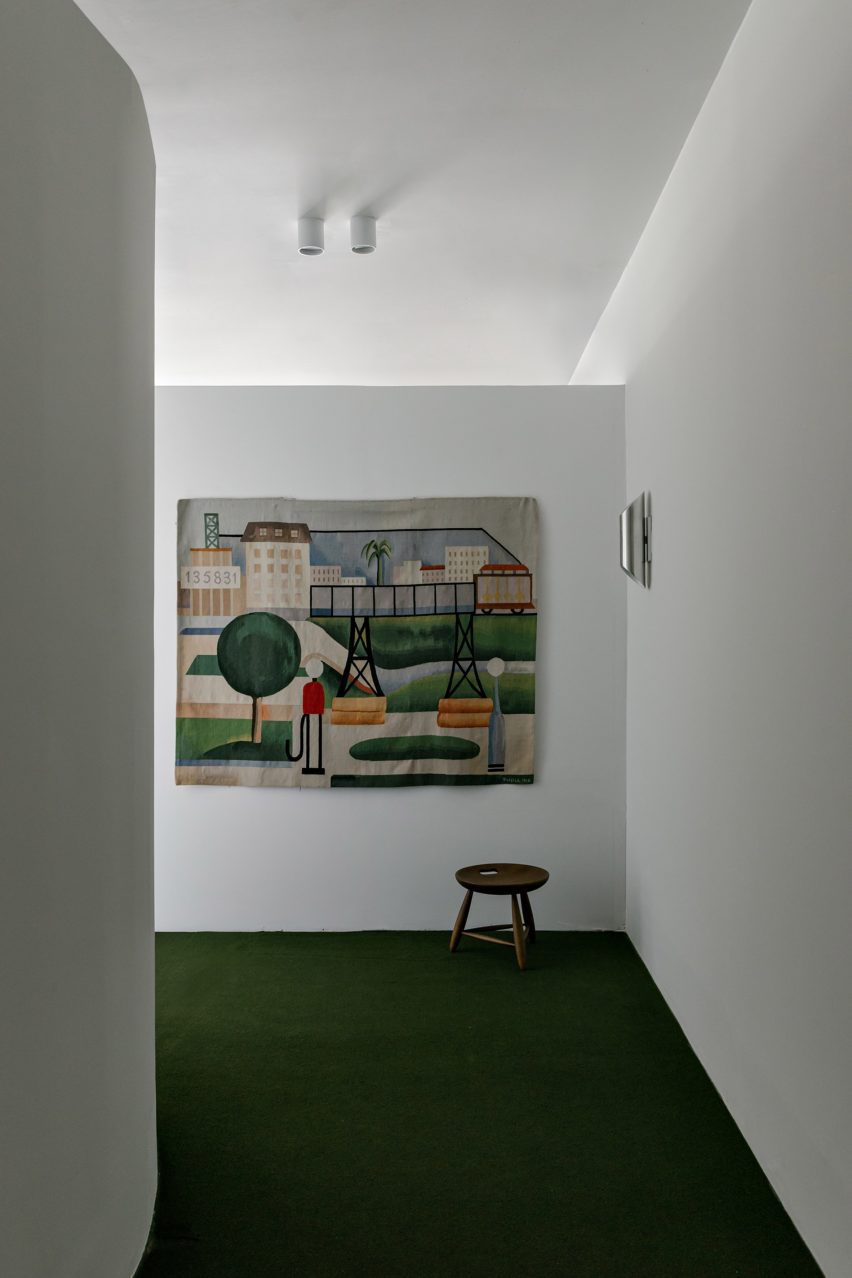 A tapestry by Brazilian artist Tarsila do Amaral adds color to a white wall