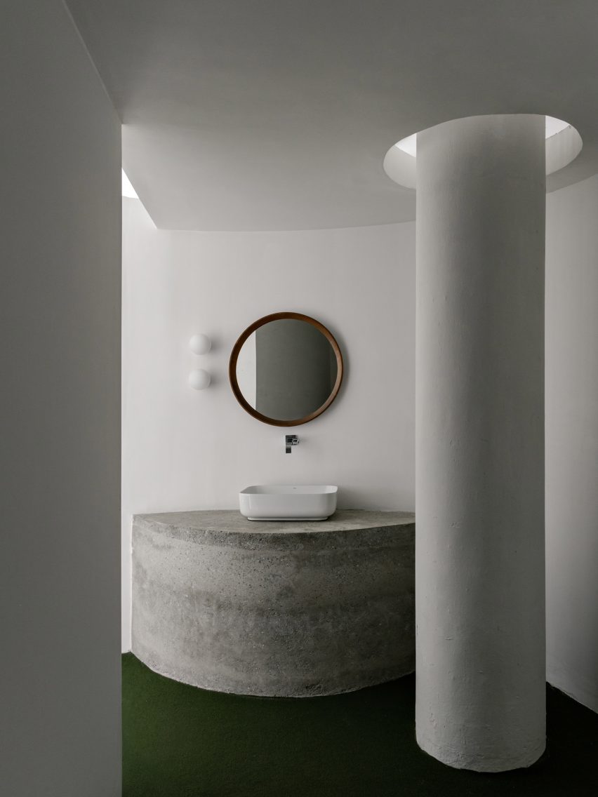 Precast-concrete vanity with a basin on top, next to a white column