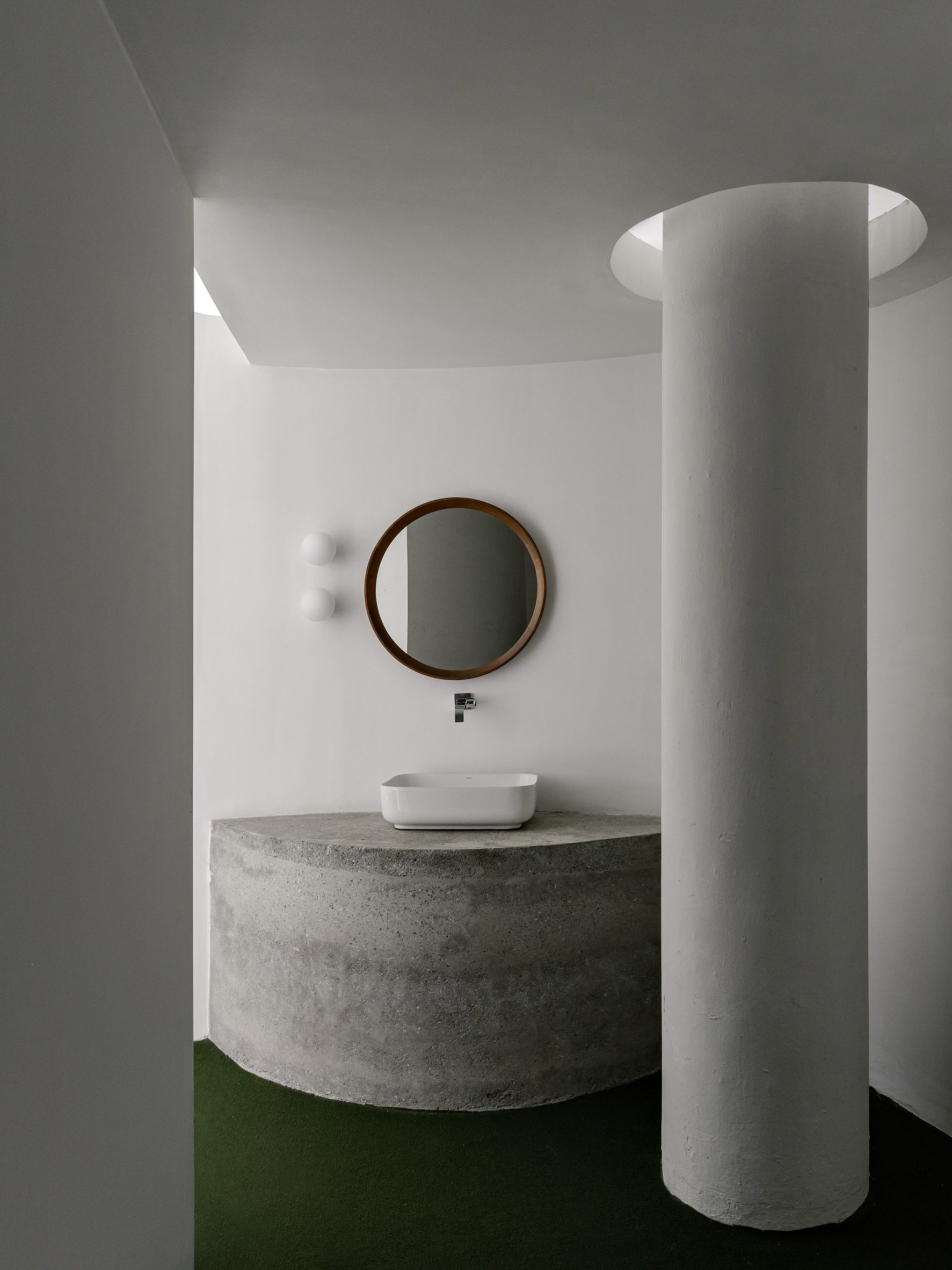 Precast-concrete vanity with a basin on top, next to a white column