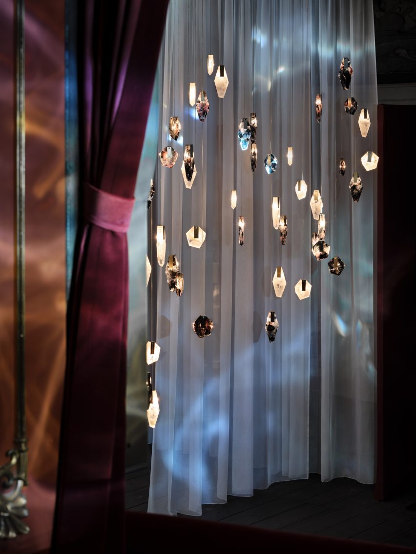 Historic theatre stage filled with sheer curtains and hanging crystal-like lights